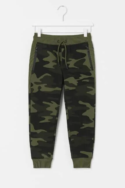 Pantalon de sport garçon camouflage vert – vue de face Pantalon de sport garçon camouflage – vue de dos Détail tissu camouflage pantalon de sport garçon